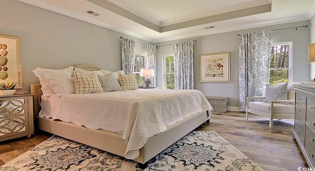 2038 Lone Cypress Dr, Myrtle Beach, SC 29579 - bedroom with a tray ceiling, multiple windows, crown molding, and hardwood / wood-style flooring