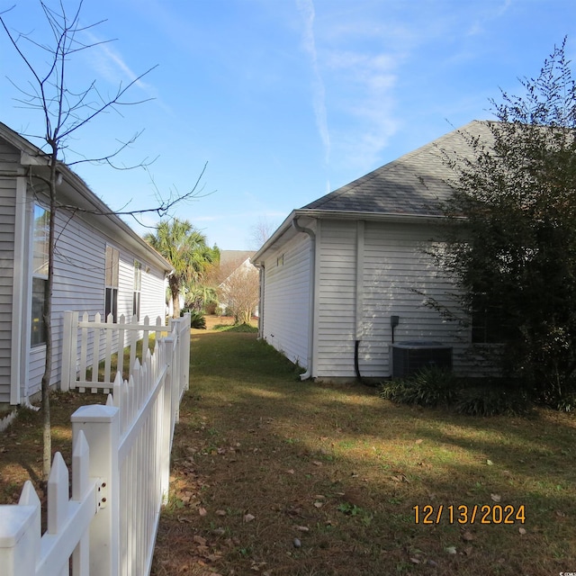 view of side of property with a yard and cooling unit