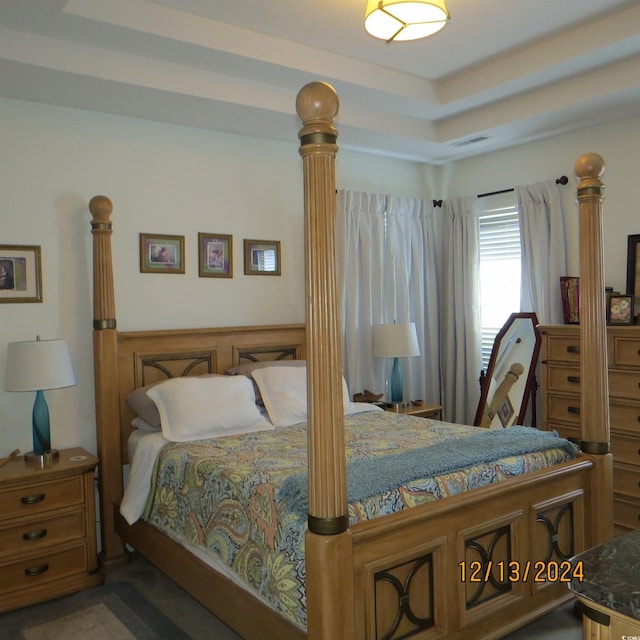 bedroom featuring wood walls and a tray ceiling