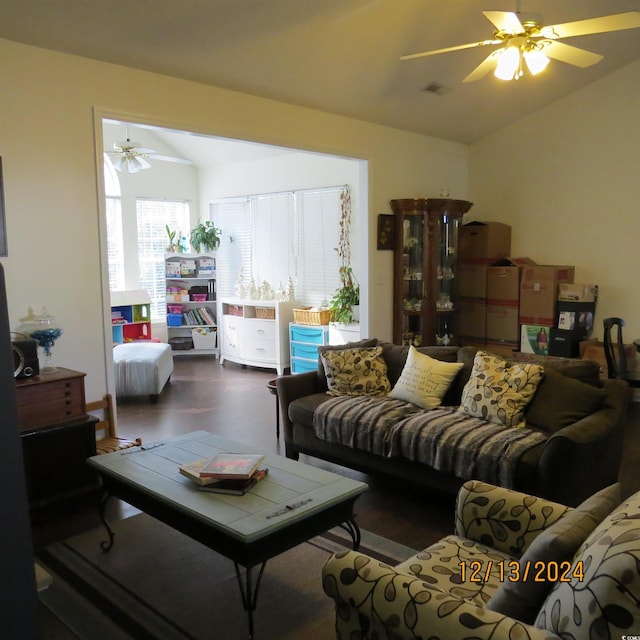 living room with ceiling fan, dark hardwood / wood-style flooring, and vaulted ceiling