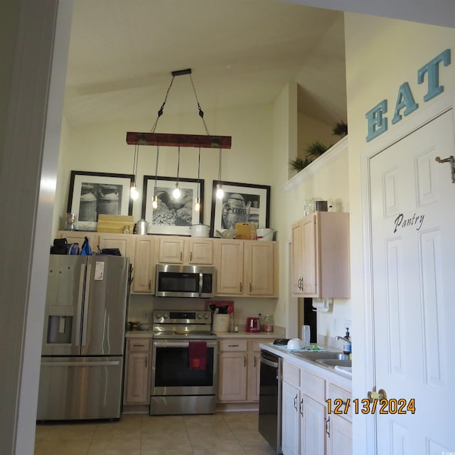 kitchen featuring sink, light brown cabinets, stainless steel appliances, vaulted ceiling, and light tile patterned flooring