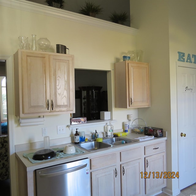 kitchen with light brown cabinetry, stainless steel dishwasher, and sink