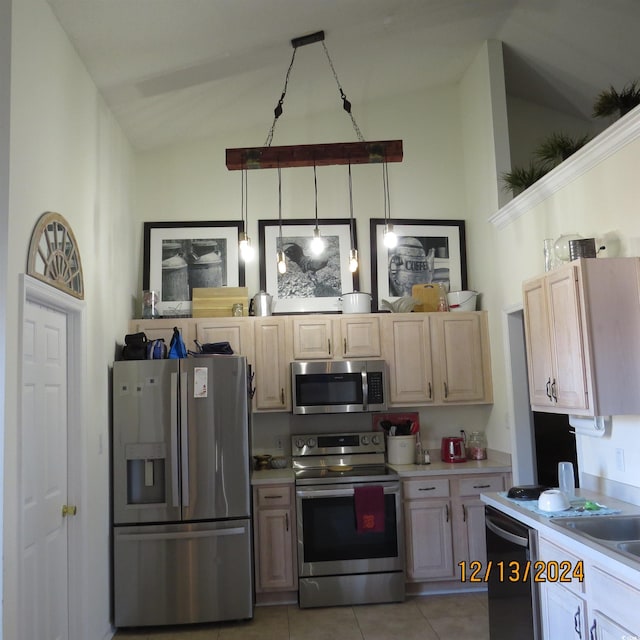 kitchen with stainless steel appliances, vaulted ceiling, light brown cabinets, hanging light fixtures, and light tile patterned flooring