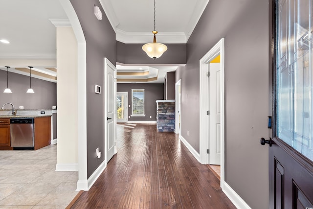 entrance foyer with a fireplace, hardwood / wood-style floors, crown molding, and sink