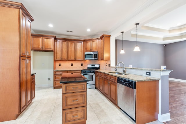 kitchen featuring dark stone counters, sink, appliances with stainless steel finishes, a kitchen island, and kitchen peninsula