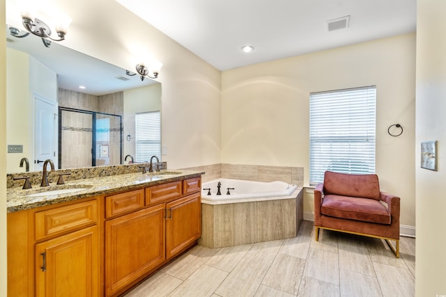 bathroom featuring vanity and independent shower and bath