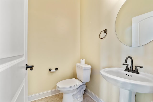 bathroom featuring toilet, tile patterned flooring, and sink