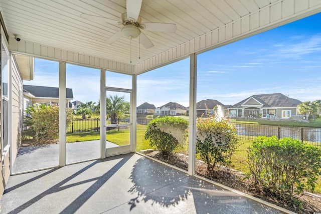 unfurnished sunroom featuring ceiling fan