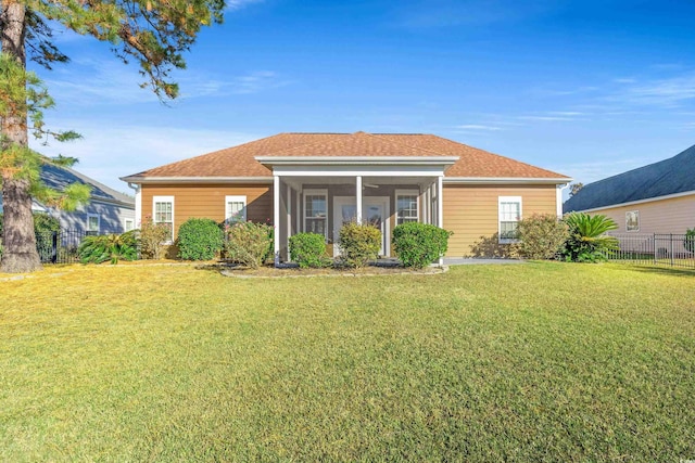 rear view of house featuring a sunroom and a yard