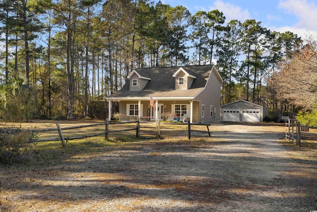 new england style home featuring a garage, covered porch, and an outdoor structure