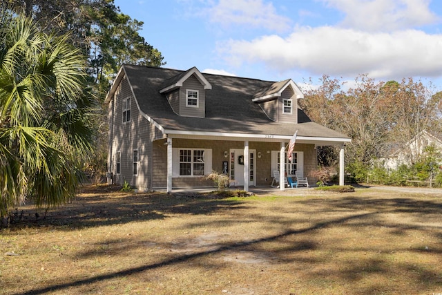 cape cod house featuring covered porch and a front yard