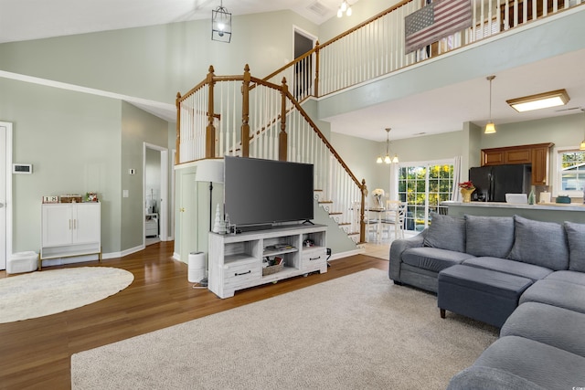 living room featuring a notable chandelier, dark hardwood / wood-style flooring, and high vaulted ceiling