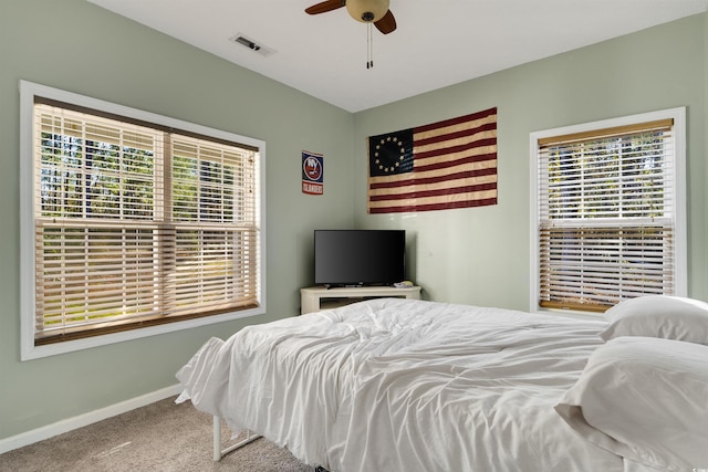 carpeted bedroom featuring ceiling fan and multiple windows