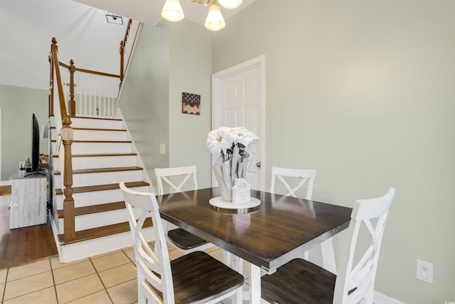 dining area with light tile patterned flooring and an inviting chandelier