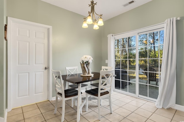 dining space featuring light tile patterned flooring and an inviting chandelier