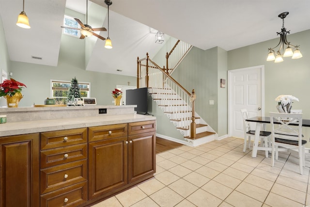 kitchen featuring ceiling fan with notable chandelier, light tile patterned flooring, and decorative light fixtures