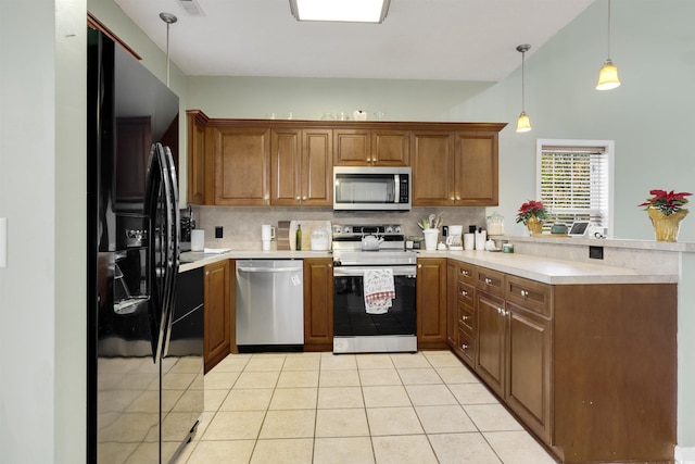 kitchen featuring decorative backsplash, light tile patterned floors, appliances with stainless steel finishes, decorative light fixtures, and kitchen peninsula