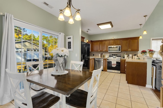 tiled dining area featuring a chandelier