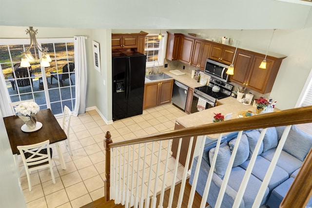 kitchen with sink, hanging light fixtures, light tile patterned floors, a notable chandelier, and stainless steel appliances