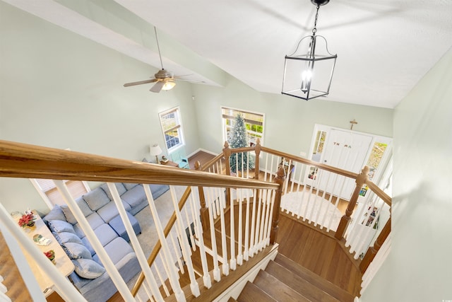 stairway featuring hardwood / wood-style floors, ceiling fan with notable chandelier, and lofted ceiling