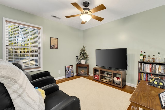 living room featuring hardwood / wood-style floors and ceiling fan