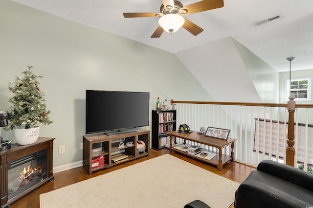 living room featuring a textured ceiling, dark hardwood / wood-style floors, ceiling fan, and lofted ceiling