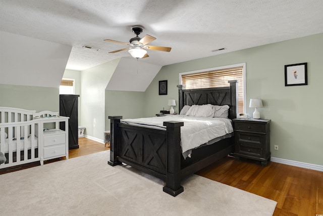 bedroom with hardwood / wood-style floors, a textured ceiling, ceiling fan, and lofted ceiling