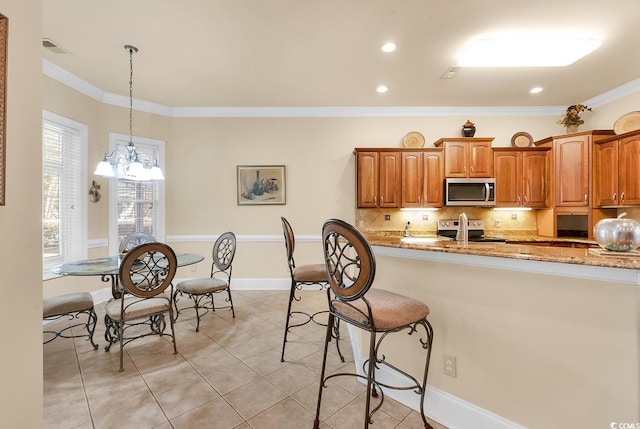 kitchen with light stone counters, ornamental molding, stainless steel appliances, decorative light fixtures, and an inviting chandelier