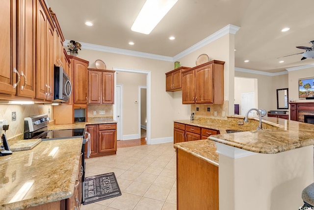 kitchen featuring crown molding, decorative backsplash, light stone countertops, appliances with stainless steel finishes, and kitchen peninsula