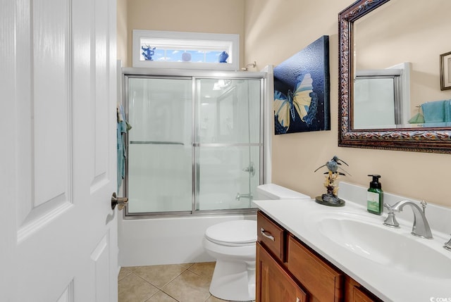 full bathroom featuring tile patterned floors, vanity, bath / shower combo with glass door, and toilet