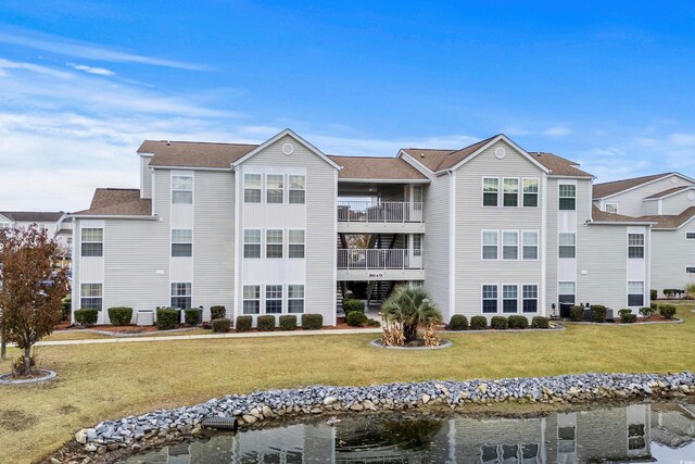 view of building exterior with a water view and central AC unit