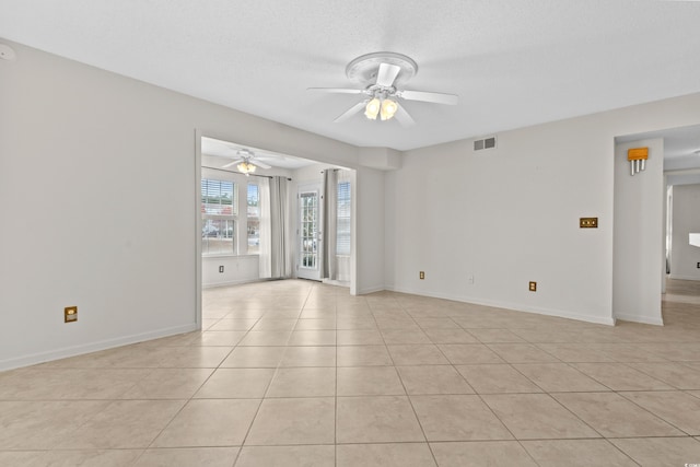 spare room with ceiling fan, light tile patterned floors, and a textured ceiling