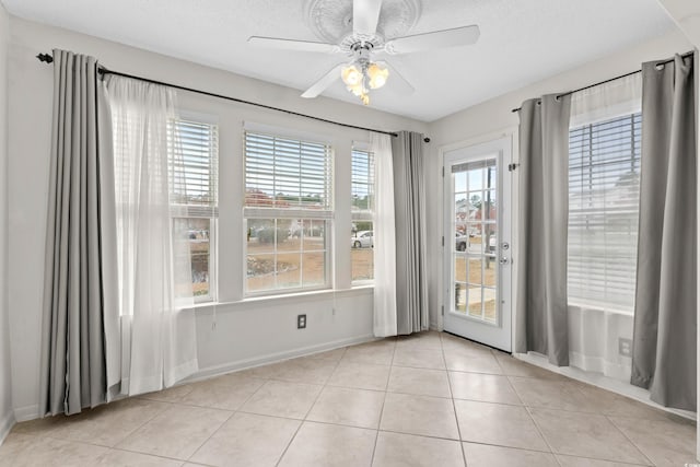 interior space with light tile patterned floors, a textured ceiling, and ceiling fan