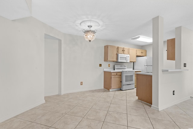 kitchen with light tile patterned floors, hanging light fixtures, white appliances, and a notable chandelier