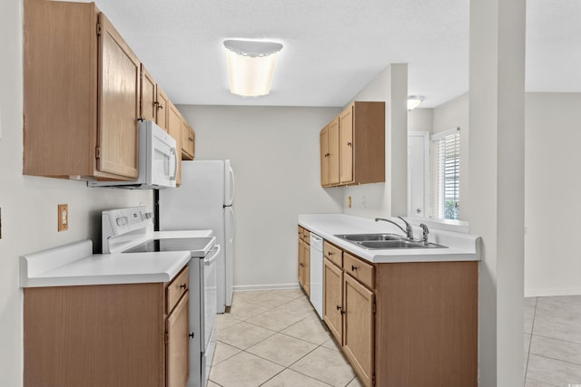 kitchen featuring light tile patterned floors, white appliances, a textured ceiling, and sink