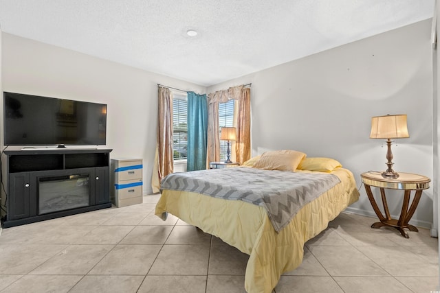 bedroom featuring light tile patterned flooring and a textured ceiling