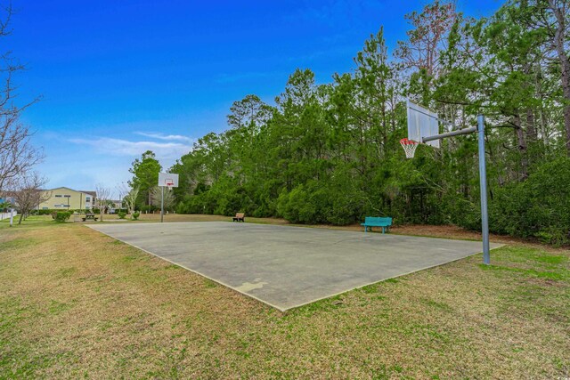 view of basketball court with a yard