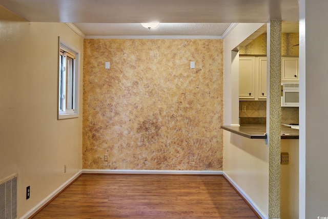 unfurnished room featuring hardwood / wood-style flooring and ornamental molding