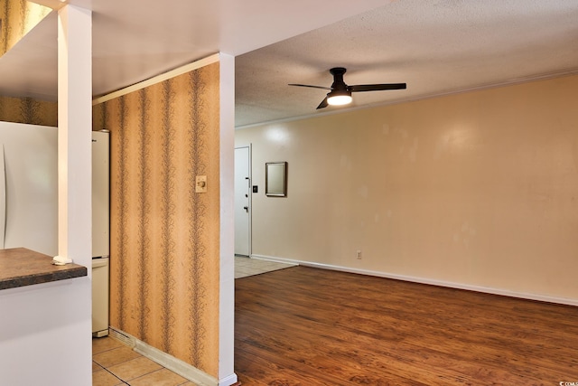 kitchen with crown molding, hardwood / wood-style floors, ceiling fan, and a textured ceiling