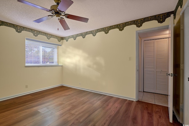 spare room with a textured ceiling, hardwood / wood-style flooring, and ceiling fan