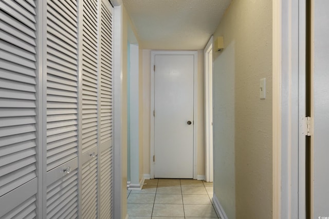 hallway featuring light tile patterned floors and a textured ceiling