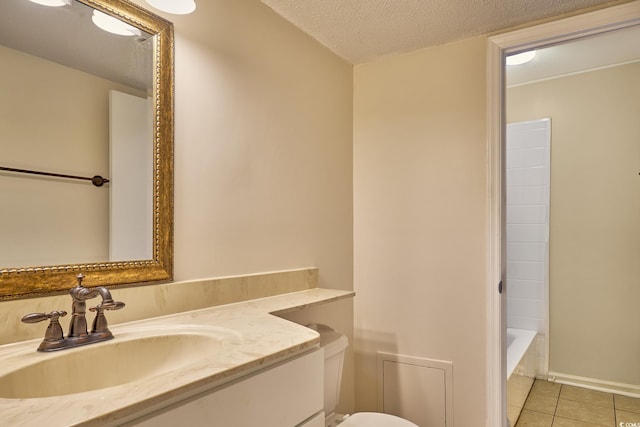 bathroom with tile patterned flooring, vanity, a textured ceiling, and a tub to relax in