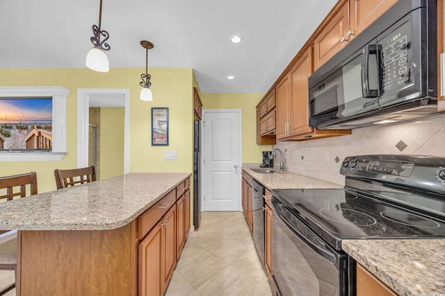 kitchen featuring black appliances, sink, decorative backsplash, decorative light fixtures, and a breakfast bar area