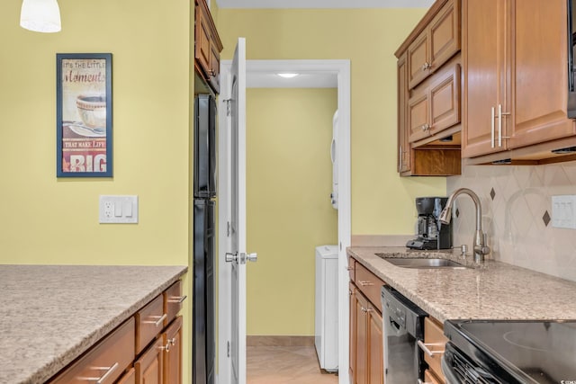 kitchen with backsplash, black fridge, stainless steel dishwasher, sink, and pendant lighting