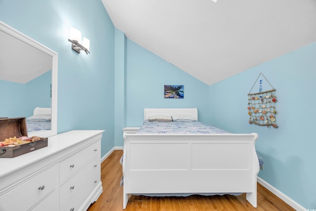 bedroom featuring vaulted ceiling and light hardwood / wood-style flooring