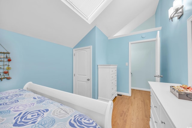 bedroom featuring light wood-type flooring and vaulted ceiling