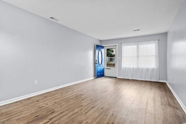 spare room featuring a textured ceiling and hardwood / wood-style flooring