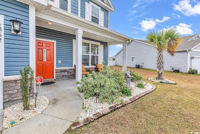 entrance to property featuring a lawn, central air condition unit, and covered porch