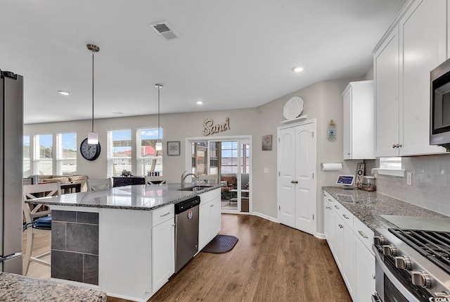 kitchen with dark hardwood / wood-style floors, white cabinetry, an island with sink, and appliances with stainless steel finishes