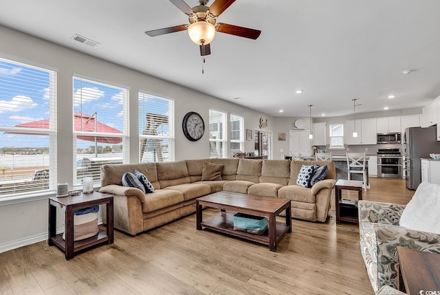 living room with ceiling fan and light hardwood / wood-style floors